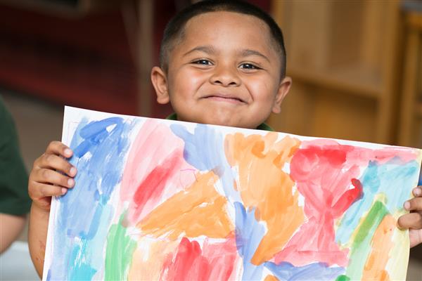 A student shows off his painting.  